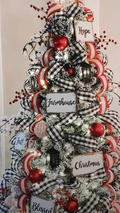 a christmas tree decorated with red, white and black ribbon