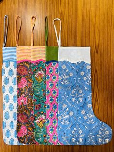 four pieces of fabric hanging from hooks on a wooden table