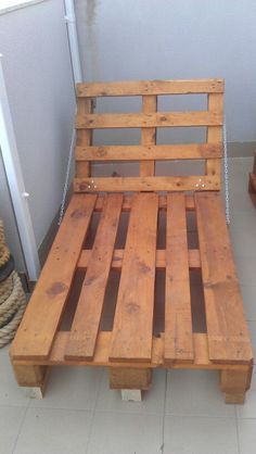 a wooden bench made out of pallets on top of a tile floor next to a door