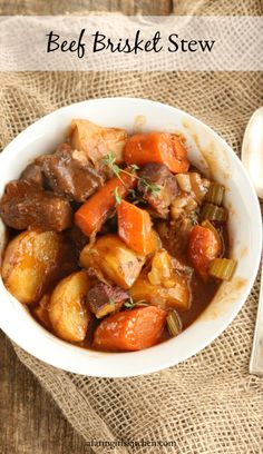 beef and potatoes stew in a white bowl on a burlied cloth with spoons