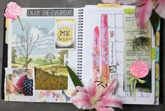 an open planner book with pink flowers and pictures on the pages, next to a flower