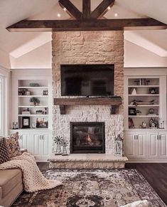 a living room with a couch, fireplace and television on the wall in front of it