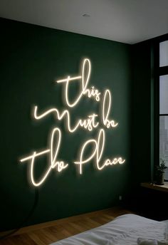 this must be the plan neon sign on wall next to bed in dark green room