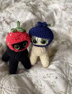 two small crocheted animals sitting on top of a bed