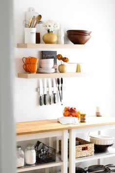 the kitchen is clean and ready for us to use it's shelves are filled with utensils