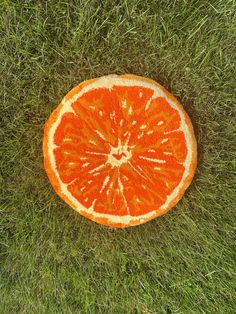 an orange cut in half laying on the grass