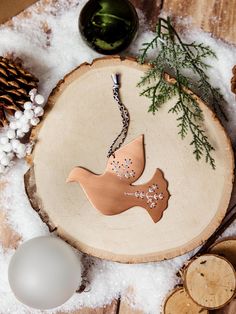 a wooden ornament with a bird hanging from it's side on top of snow