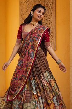 Brown attached cancan lehenga with ganesha and cows kalamkari hand painted patterns. Paired with padded maroon embroidered blouse and pink printed dupatta. - Aza Fashions Anarkali Tussar Silk Lehenga For Navratri, Navratri Anarkali Tussar Silk Lehenga, Semi-stitched Tussar Silk Sharara For Navratri, Unstitched Anarkali Set With Kalamkari Print For Wedding, Anarkali Tussar Silk Lehenga With Pallu, Tussar Silk Sharara With Cutdana For Navratri, Floor-length Kalamkari Anarkali Set For Wedding, Tussar Silk Chandbali Lehenga For Diwali, Tussar Silk Lehenga For Diwali With Chandbali Shape