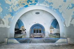 the inside of an abandoned building with blue and white paint on the walls, stairs and railings