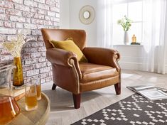 a brown leather chair sitting next to a window