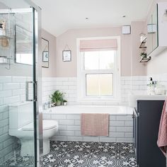 a bathroom with pink walls and white tiles on the floor, along with a bathtub