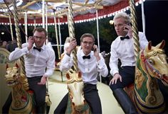 three men in white shirts and bow ties riding on a merry go round