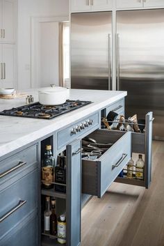 an open drawer in the middle of a kitchen counter next to a stove and refrigerator