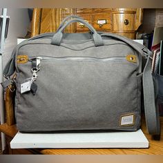 Nwot Travelon Anti-Theft Heritage Messenger Bag - Pewter Model Number: 33073 Material: Cotton/Polyester Blend Dimensions: 16.75" X 11.5" X .4" Linear: 28.65" Capacity: 77 Cu. In. / 1.2 L Weight: 1.8 Lbs. Roomy Main Compartment With Padded Pocket For A Laptop To 15.6”, A Zippered Rfid Blocking Pocket, And An Open Top Wall Pocket Front And Rear Zippered Pockets Zippered Organizer Compartment With 2 Open Top Wall Pockets, 2 Pen Loops And A Tethered Key Clip With Led Light Add-A-Bag Strap Full Anti- Travelon Bags, Pewter Color, Key Clip, Wall Pockets, Anti Theft, Open Top, Bag Straps, Led Light, Messenger Bag