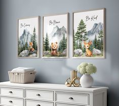 three paintings on the wall of a room with two bears and one bear cub sitting in front of them