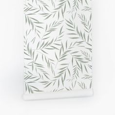 a white and green wallpaper with leaves on it's back side, in front of a white background