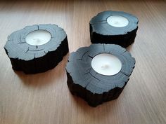 three tea lights sitting on top of a wooden table