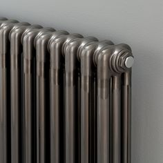 an old fashioned radiator is shown against the wall in this image, it's dark and shiny