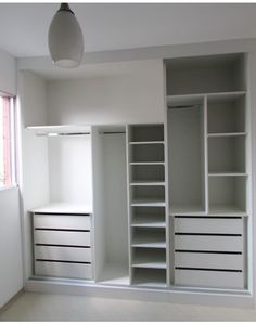 an empty room with white shelves and drawers