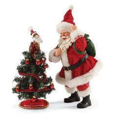 a santa clause standing next to a small christmas tree