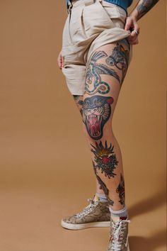 a man with tattoos on his legs posing for the camera