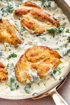 some chicken is covered in white sauce and garnished with parsley