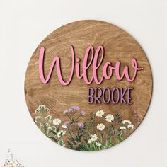 a wooden sign that says willow brooke with daisies and daisies in the background