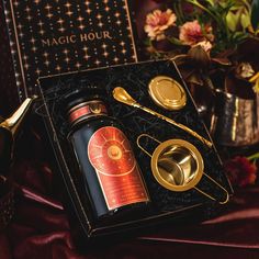 a black box with gold spoons and other items in it on a red table cloth