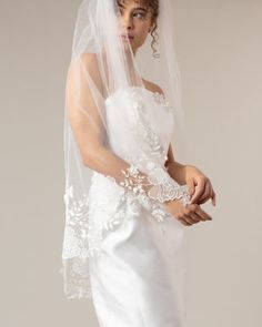 a woman wearing a wedding veil and dress