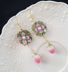 pink and green flower earrings on a white plate