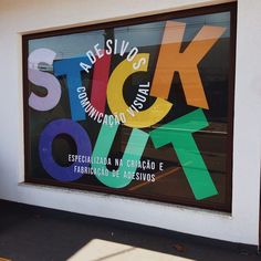 a store front window with colorful stickers on it's glass and the words stick out