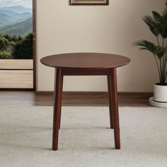 a small wooden table sitting on top of a carpeted floor next to a potted plant