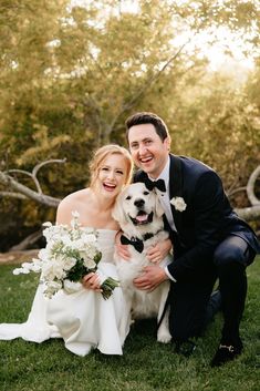 a bride and groom pose with their dog