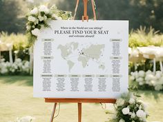 a wedding seating chart on a easel with flowers and greenery in the background