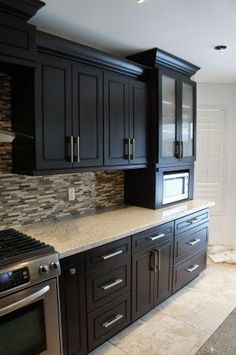 a kitchen with black cabinets and granite counter tops is featured in the pinterest