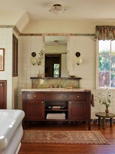 a bathroom with a tub, sink and mirror in it's centerpieces