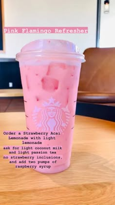 a pink drink sitting on top of a wooden table