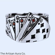 a ring with four playing cards on the front and two red stones in the middle