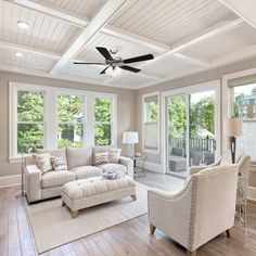 a living room with two couches, chairs and a ceiling fan in the center