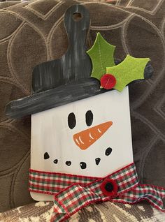 a wooden snowman ornament hanging on a couch