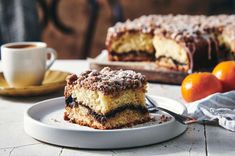 a piece of cake sitting on top of a plate next to a cup of coffee