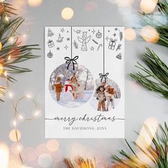 a christmas card with two people hanging from the front and back of it, surrounded by lights