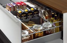 an open drawer with spices and condiments in the bottom compartment on a kitchen counter