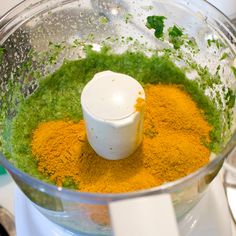 a blender filled with green and yellow ingredients