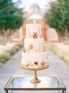 a wedding cake sitting on top of a glass table