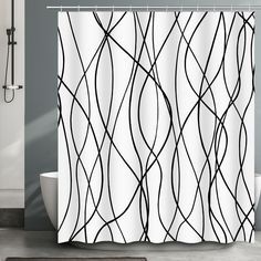 a shower curtain with black and white lines on it in front of a bathtub