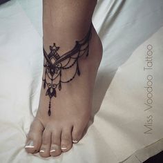 a woman's foot with an owl tattoo on the top and bottom of it