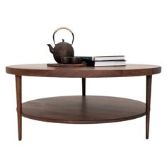 a coffee table with a tea pot on top and books sitting on the bottom shelf