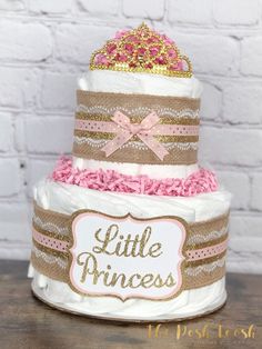 a little princess diaper cake with pink and gold trimmings on the top