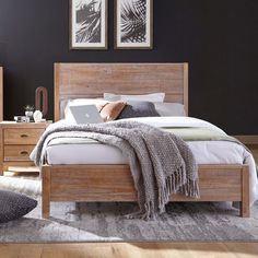 a bed room with a neatly made bed and two pictures on the wall above it